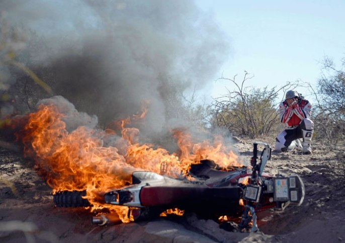 Foto: www.chinadaily.com.cn;Nešťastný Paulo Gonçalves pri svojom horiacom motocykli;