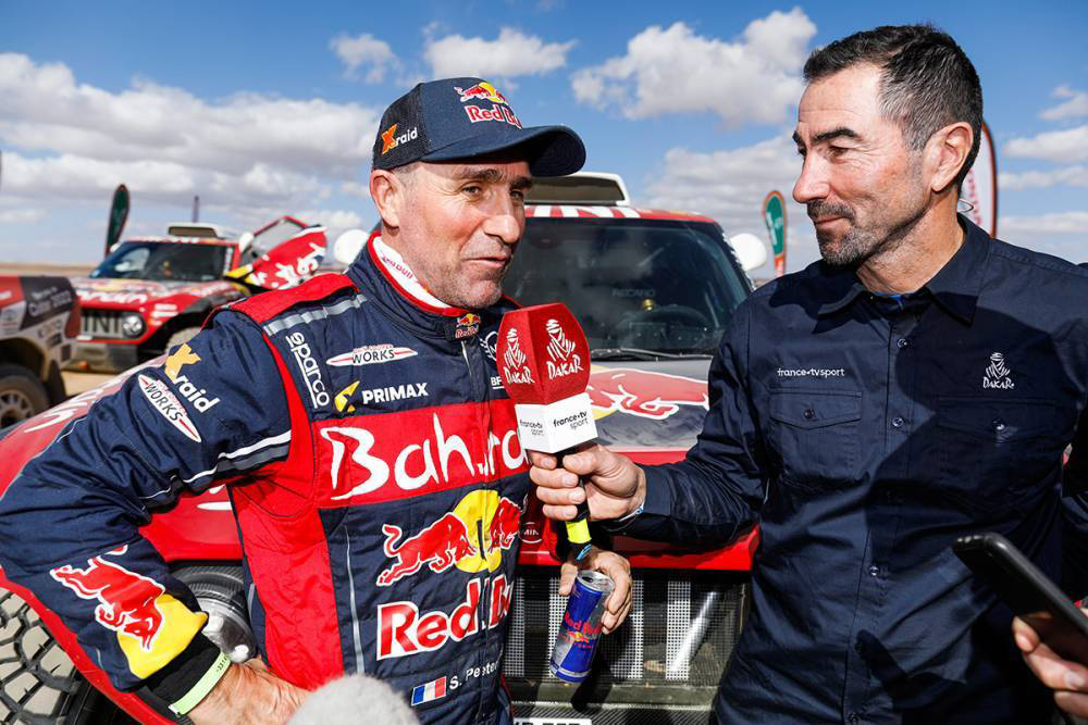 dakar.com;Trinásťnásobný víťaz (z toho šesťkrát na motocykli) Rallye Dakar Francúz Stéphane Peterhansel (vľavo) vyhral v tomto ročníku zatiaľ dve etapy a v priebežnom poradí mu patrila v polovici pretekov výborná 3. priečka.